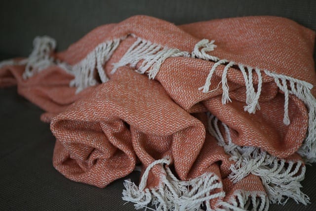 Una mantita confortable en el sofa para tu estilo hygge.